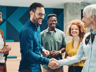 Hände schütteln im Team, Verhandlung erfolgreich, lachend