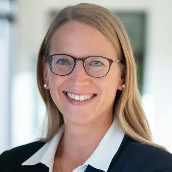 a woman wearing glasses and a black jacket